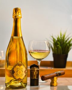 Sparkling Bee d'Vine honey mead wine mead next to glass of still wine and cigar