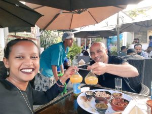 Ayele and friend drinking tej, Ethiopian mead honey wine in berele glass flasks paired with kitfo Ethiopian tartare dish
